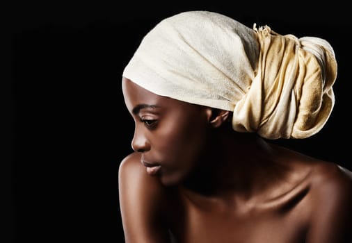 Simplicity is the keynote of elegance. Studio shot of a beautiful woman wearing a headscarf against a black background.