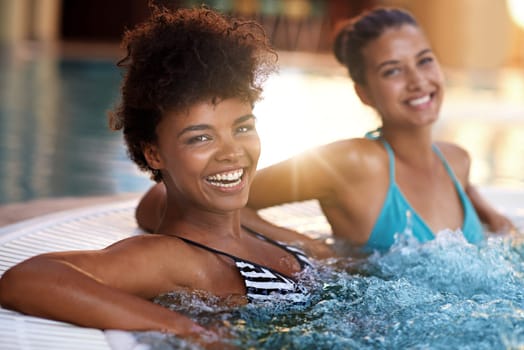 If you have friends, you have everything. two young women relaxing in a jacuzzi.
