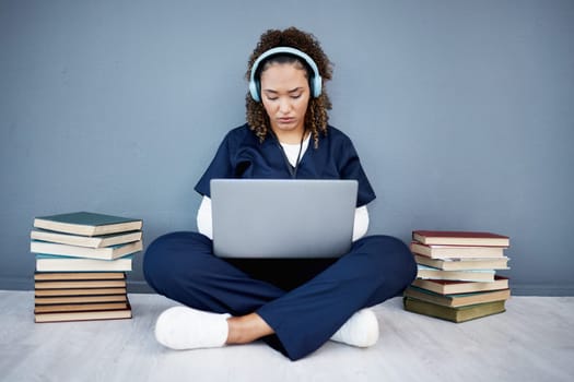 Doctor, laptop or headphones of hospital music, podcast or radio in woman study research or mock up learning by wall. Thinking, technology or medical student listening to healthcare audio for books