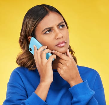 Phone call, thinking and woman confused, doubt and communication on a yellow studio background. Person, network and model with a smartphone, connection and spam problem with scam and conversation