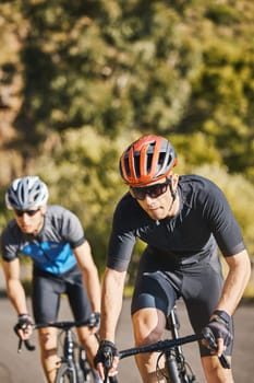 Men, mountain and cycling for race, fitness and helmet for safety, speed and training for health in summer. Young cyclist athlete, focus and exercise for wellness, performance and workout in sunshine.