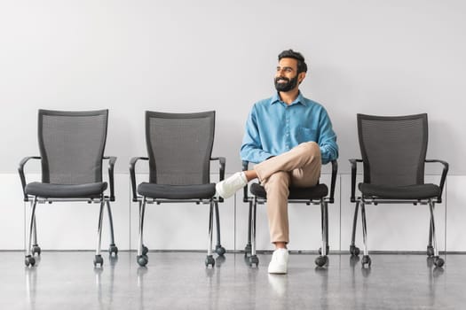 indian businessman sitting casually in waiting area