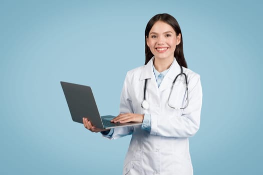 Female doctor holding laptop with smile