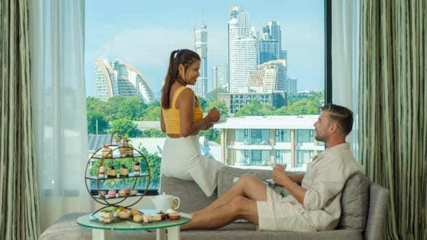 A couple of men and woman having afternoon tea or high tea in a hotel room