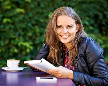 College student, portrait and reading a book at coffee shop on university, campus or restaurant. Happy, woman and learning from studying books, textbook or relax with knowledge at outdoor cafe