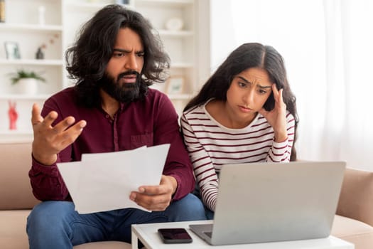 Unhappy, stressed and upset couple paying bills or debt online
