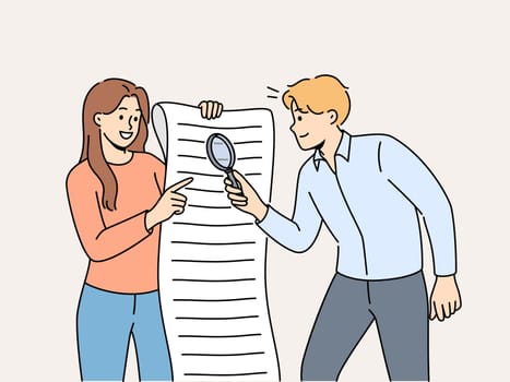 Man and woman are studying large business document using magnifying glass to look for hidden information in legal documents. Business people analyze and check data before signing contract