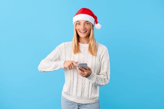 Santa-hatted lady texting on phone