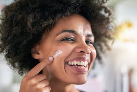 Portrait, woman and face for cream by spf in home for wellness, protection and dermatology. Black person, happy or laugh with apply for skincare by treatment, pigmentation or hydration with vitamin c