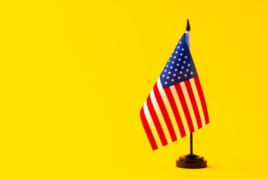 Small flag of USA on flagpole on studio background