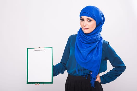 Beautiful Muslim fashion girl holding an empty banner, copy-space.