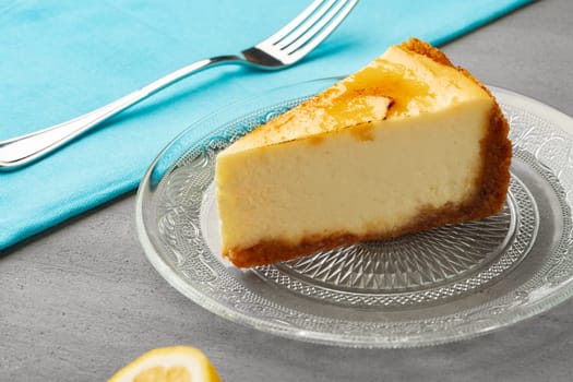Piece of lemon cheesecake on glass dish