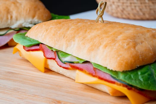 Sandwich with ham and cheese on wooden board