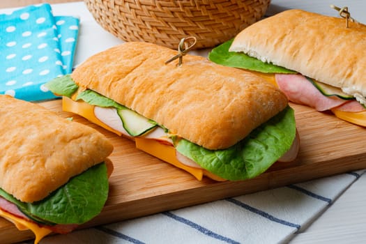Sandwich with ham and cheese on wooden board