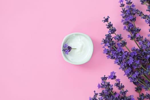 Cosmetic cream with lavender flowers top view