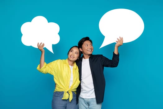 Glad young japanese guy and woman in casual hold abstract cloud with copy space for words, text