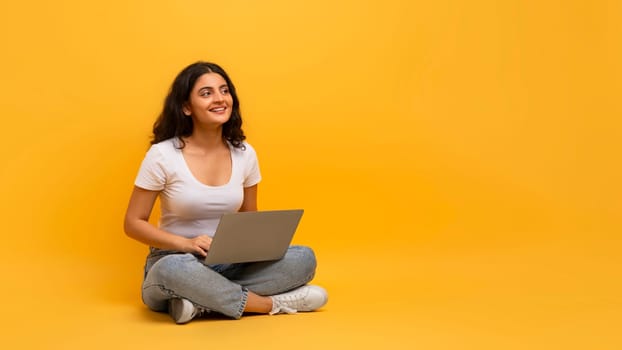 Cheerful woman student using notebook, studying online