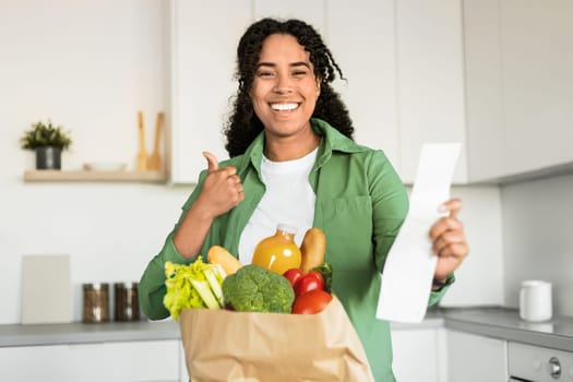 black lady reviews grocery list and giving thumbs up indoor