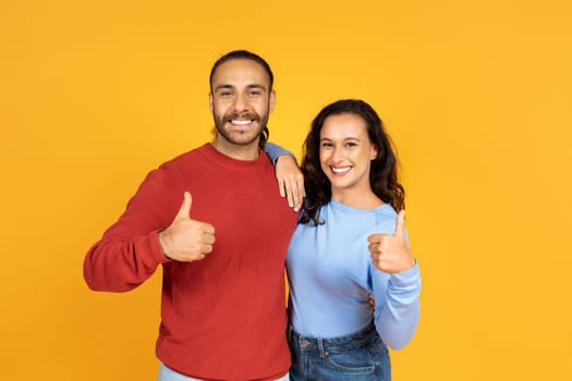 Happy millennial couple hugging and showing thumb up
