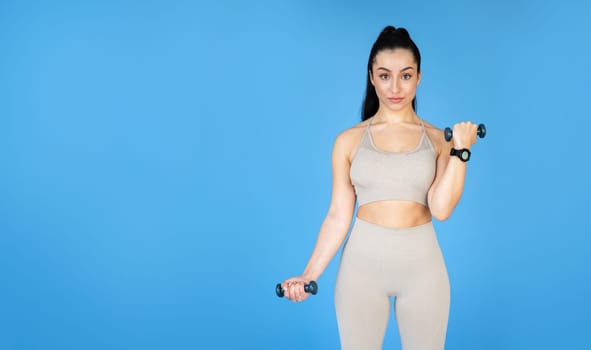 A young woman with a sporty build is doing strength exercises