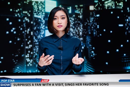 Asian presenter covers media segment
