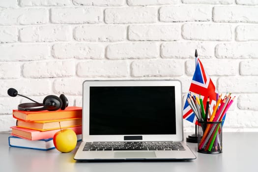 Laptop and flag of UK on desk. English language learning concept
