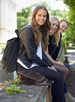 School, friends and portrait of sitting on a wall, outdoor on campus with women and happiness. Social, students and smile for learning, education and studying at academy with backpack in morning.