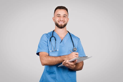 Happy male nurse with clipboard and stethoscope