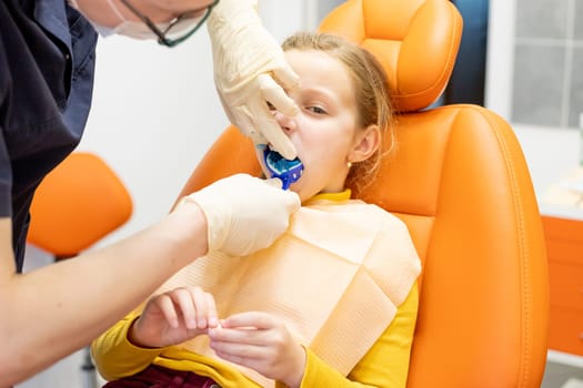 Dentist examining a patient's teeth using dental equipment impression spoon in dentistry office.Child during orthodontist visit and oral cavity check-up.Stomatology and health care
