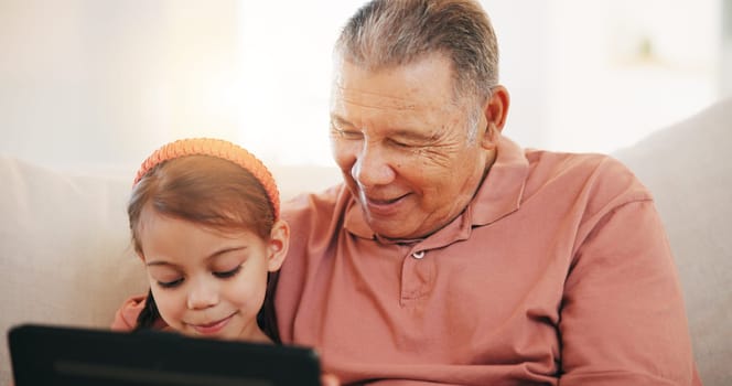 Home, grandfather on a couch and girl with tablet, happy and relax with social media, internet and digital app. Apartment, old man and pensioner with grandchild, technology and online games with fun.