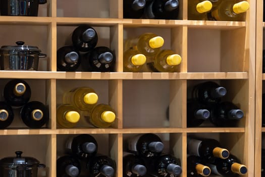A stack of wine bottles in cabinet shelving in restaurant
