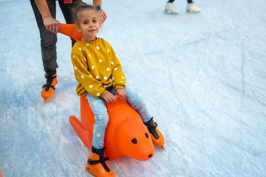 Child glides across ice rink on toy