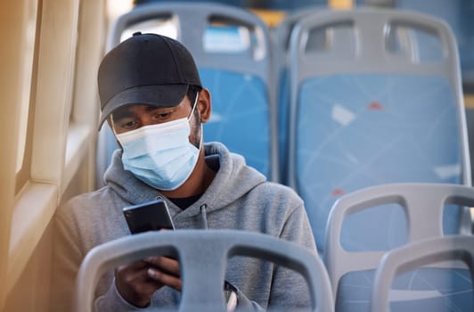 Man in bus with mask, phone and morning travel in city, checking service schedule or social media post. Public transport safety in covid, urban commute and person in seat with smartphone connection