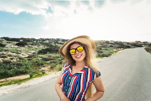 happy smiling woman on vacation with sun hat and glasses.