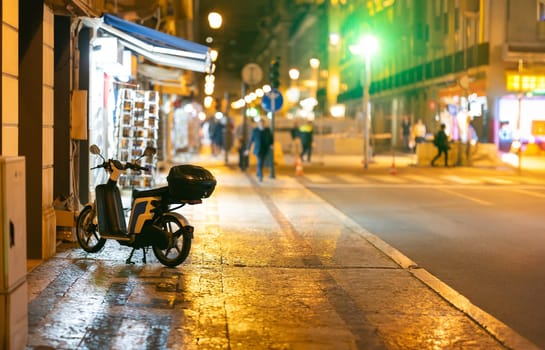 A motor scooter parked on the night street