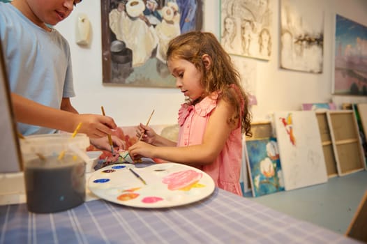 Adorable kids learn drawing in fine art gallery or creative workshop. Painting. Education. Elementary age school