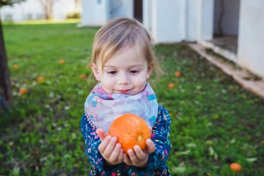 Cute baby girl showing orange