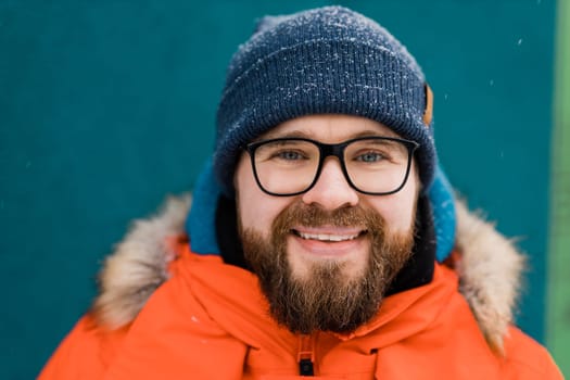 Close-up portrait of a bearded man with a beard. Snow and winter season