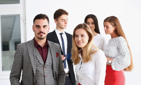 Group of smiling people stand in office