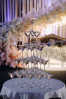 a mountain of crystal glasses with champagne. a champagne slide. supply of crystal glasses for weddings