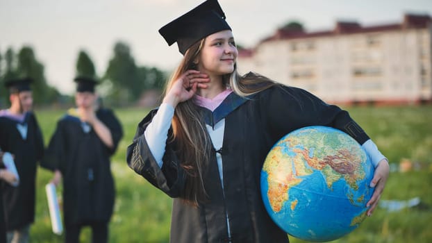 A graduate student poses with a globe in front of her friends.