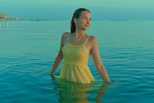 Beautiful sexy stylish Caucasian young woman model on the sea beach at sunrise.