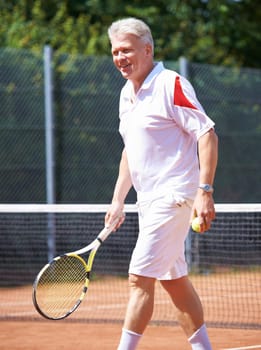 Tennis, sports and senior man on court for playing game, match and practice for competition. Retirement, happy and elderly person with racket and ball for training, exercise and workout for hobby
