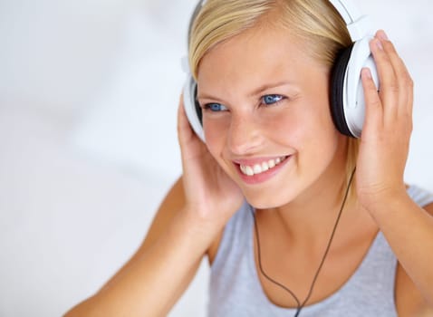 Home, thinking and woman with headphones, streaming music and smile with radio, podcast and listening to audio. Person, apartment or girl with headset, ideas and happiness with sound, joy or cheerful