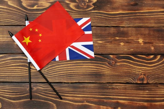 Flags of China and United Kingdom on wooden background