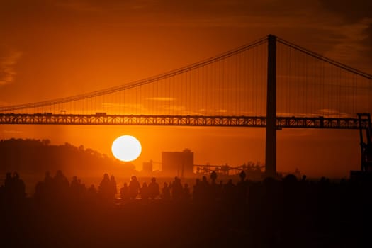 Sunset Serenity: A Majestic Suspension Bridge Bathed in the red Glow of the Setting Sun