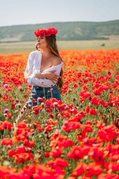 Happy woman in a poppy field in a white shirt and denim skirt with a wreath of poppies on her head posing and enjoying the poppy field.