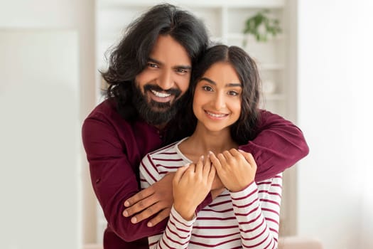 Portrait of loving indian couple posing at their new home