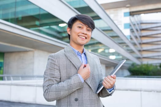 Korean entrepreneur man posing with laptop standing outdoor