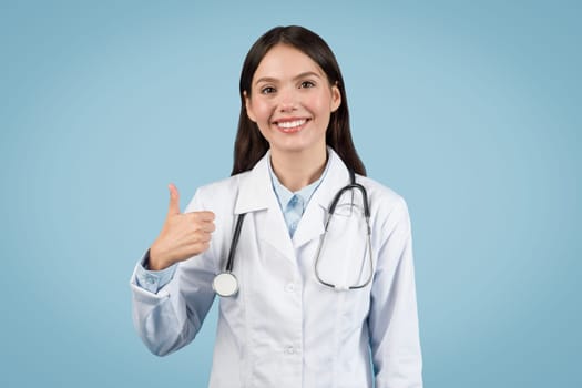 Happy female doctor in white coat with thumbs up.